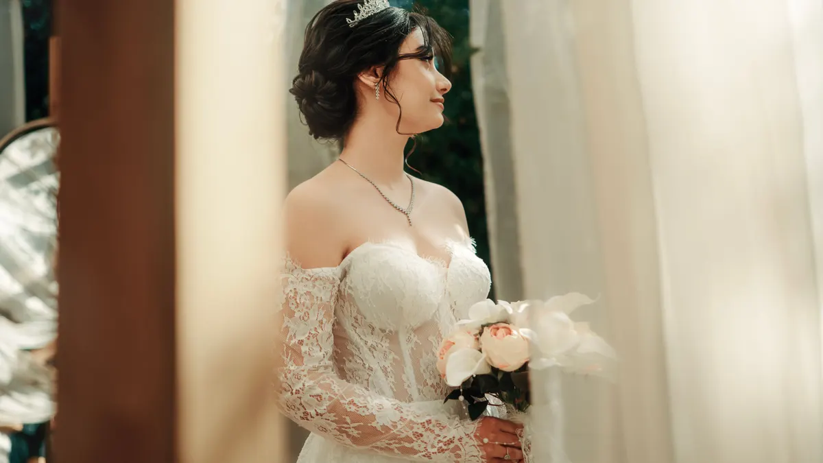 Mariée en robe de dentelle tenant un bouquet lors de la cérémonie de mariage