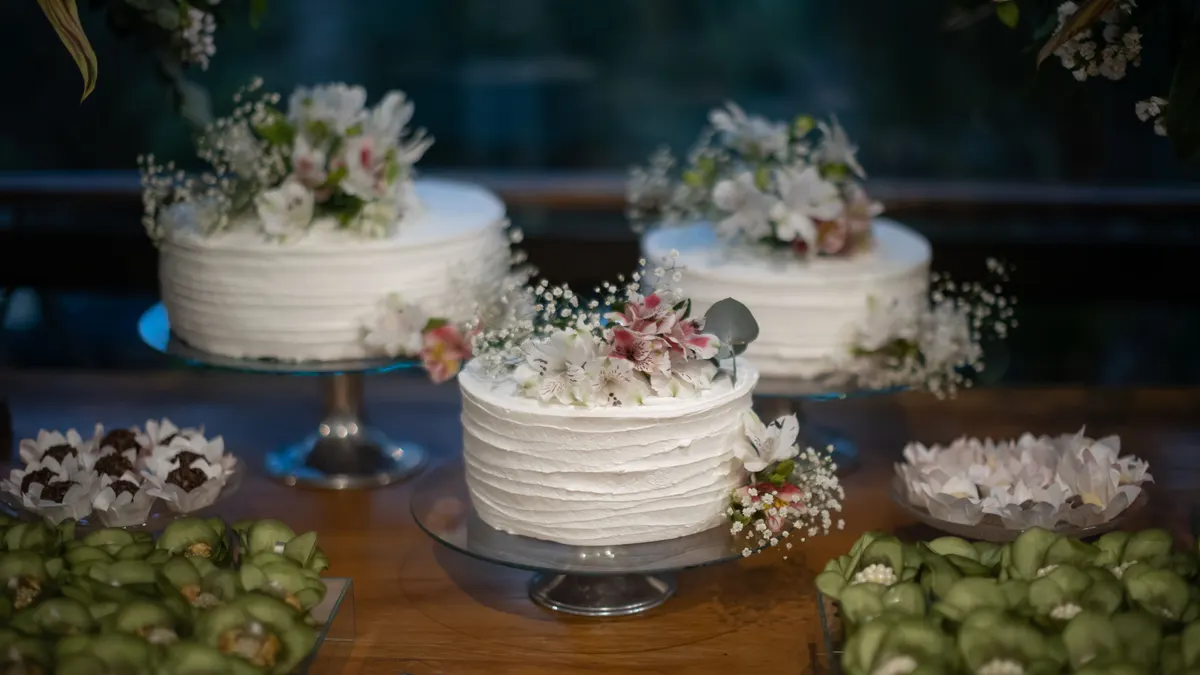 Gâteaux blancs délicats avec décorations florales, pour mariages ou occasions spéciales.